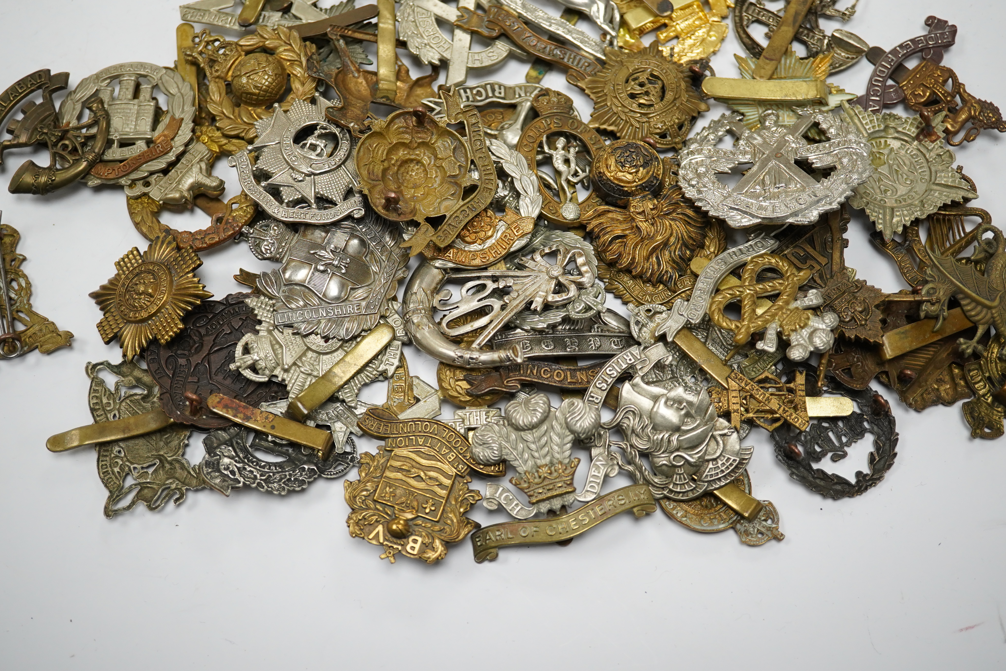 Sixty military cap badges including; the Lancashire Hussars, the Royal Corps of Signals, the Essex Regiment, the Royal Engineers, the North Stafford Regiment, the Border Regiment, the Glamorgan Yeomanry, etc. Condition f